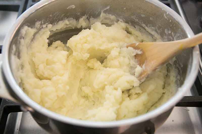 将土豆泥加入加热的牛奶和奶油中搅拌，再加入欧芹泥搅拌